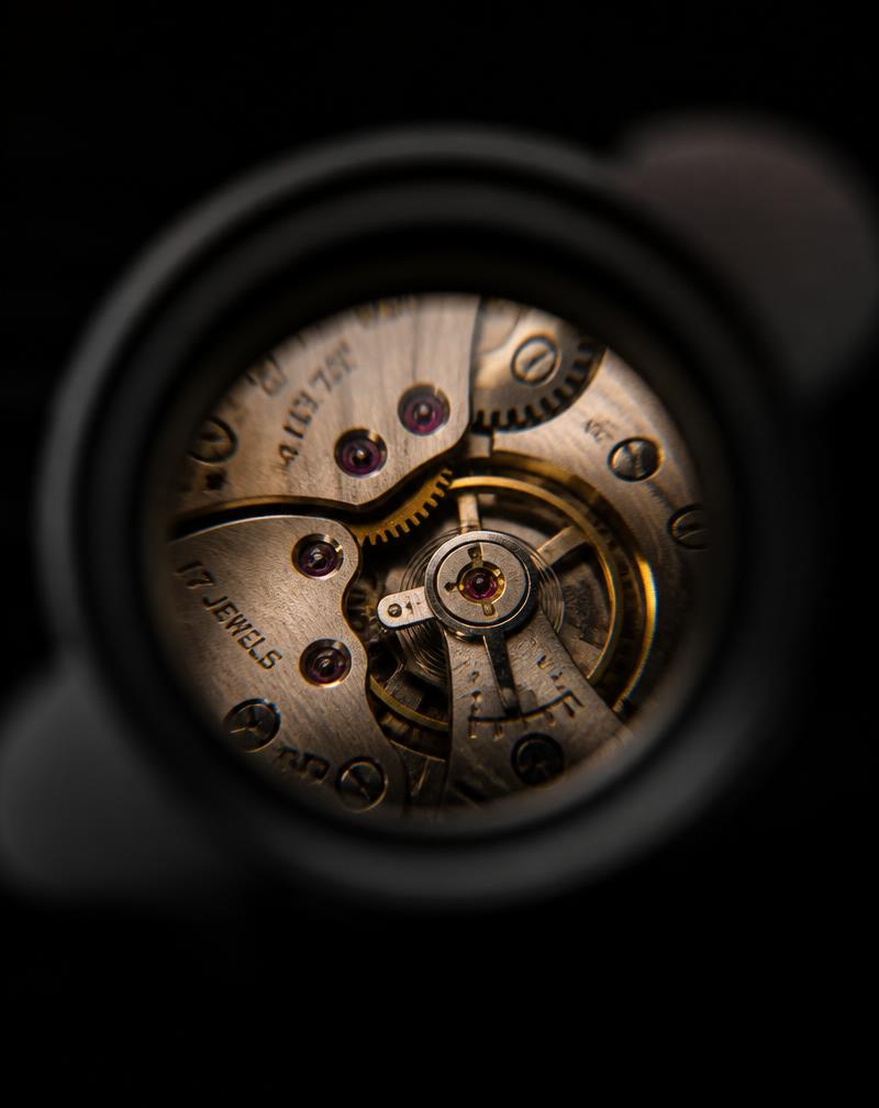 Watchmaker inspecting a mechanical movement under a jeweller's loupe